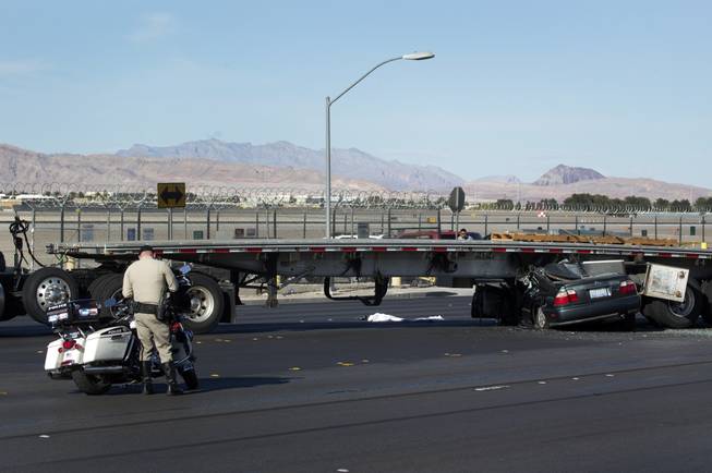 A Metro Police officer investigates an accident involving a semitrailer and a Honda Accord on Sunset Road near McCarran International Airport Tuesday, April 25, 2017.