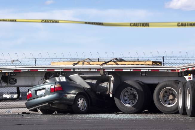 A Honda Accord is shown wedged under a semitrailer after an accident on Sunset Road near McCarran International Airport Tuesday, April 25, 2017.