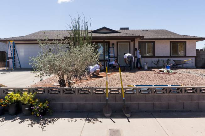 Volunteers with Rebuilding Together Southern Nevada (RTSNV)  a local affiliate of the national nonprofit organization, Rebuilding Together  help revitalize the exterior of Jocelyn Sims' home during National Rebuilding Day, Saturday, April 29, 2014. Sims was one of the first residents in the area of to move in when her house was built in 1980.