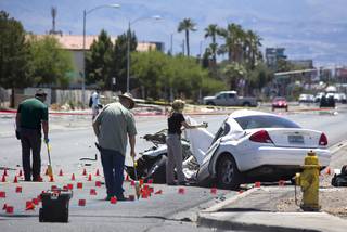 Metro Police investigators take measurements and photos following a fatal accident involving a car and a Clark County School District bus on Nellis Boulevard at Carey Avenue Thursday, May 4, 2017.