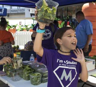 Fresh lettuce is hawked by May Elementary students during a farmers market at Zappos sponsored by Green Our Planet, an organization that has overseen the development of more than 100 gardens at local schools to help teach STEM in schools on Thursday, May 4, 2017.