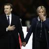 French President-elect Emmanuel Macron holds hands with his wife, Brigitte, during a victory celebration outside the Louvre museum in Paris, Sunday, May 7, 2017. Speaking to thousands of supporters from the Louvre Museum's courtyard, Macron said that France is facing an "immense task" to rebuild European unity, fix the economy and ensure security against extremist threats. 
