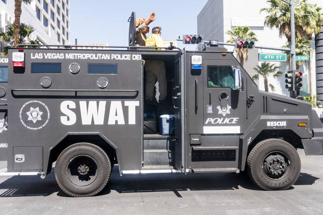 McGruff the Crime Fighting Dog waves to the crowd from a swat tank during the Helldorado parade, Saturday, May 13, 2017.