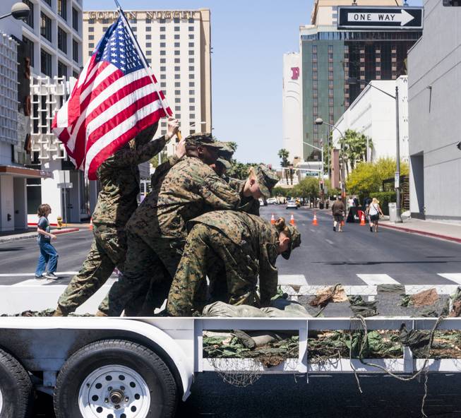 Members of the U.S. Marine Corps Junior Reserve reenact  the scene from the iconic WWII photo "Raising the Flag on Iwo Jima" during the Helldorado parade, Saturday, May 13, 2017.