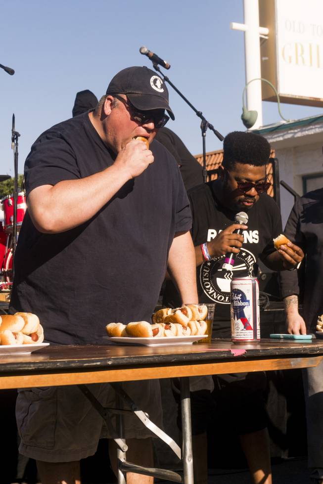 The Emcee, right, joins contest winner Chris Burke, left, during the Teenie Weenie Hotdog Eating Contest at the annual Dillinger Block Party in Boulder City, NV, Saturday 13, 2017.