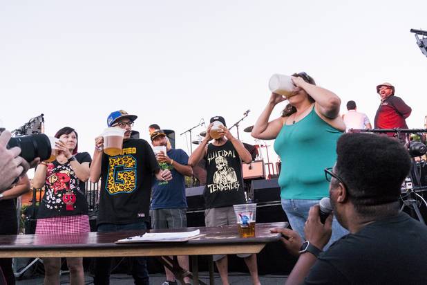 Beer drinking contestants stop drinking to watch Sarah Cutts finish her beer beating them by more than half the time during the beer drinking contest at the annual Dillinger Block Party in Boulder City, NV, Saturday 13, 2017.