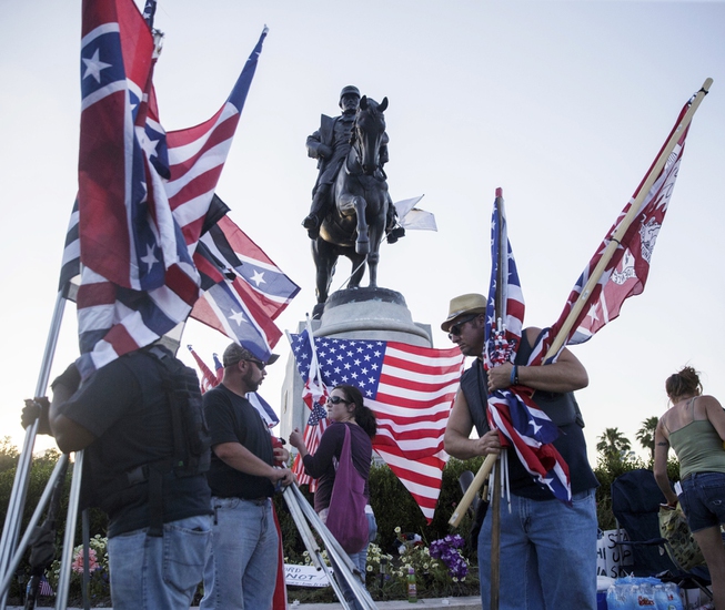 Monument supporters collect their flags before the removal of a ...