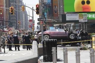 A car rests on a security barrier in New York's Times Square after driving through a crowd of pedestrians, injuring at least a dozen people, Thursday, May 18, 2017.  (AP Photo/Mary Altaffer)