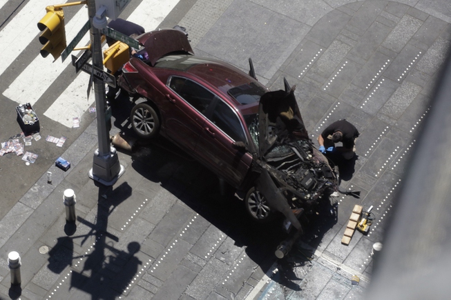 A police officer inspects a car crash, Thursday, May 18, ...