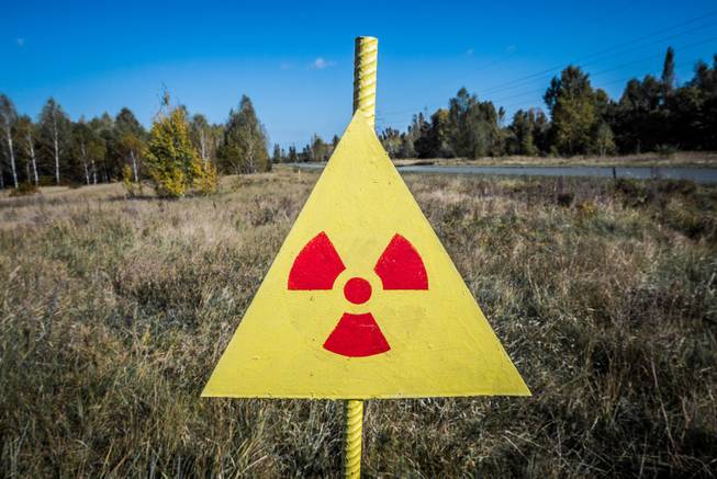 Radiation sign next to Red Forest in the Chernobyl Nuclear Power Plant Zone of Alienation, Ukraine.