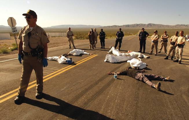 Protesters of the proposed Yucca Mountain nuclear waste repository and weapons testing lie on the pavement after crossing the line into the Nevada Test Site in Mercury. During the spring 2003 demonstration, 34 people were arrested for trespassing.
