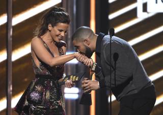 Drake kisses presenter Kate Beckinsale's hand as he walks on stage to accepts the award for top male artist at the Billboard Music Awards at the T-Mobile Arena on Sunday, May 21, 2017, in Las Vegas. (Photo by Chris Pizzello/Invision/AP)