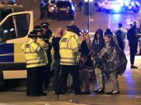 Emergency services personnel speak to people outside Manchester Arena after reports of an explosion at the venue during an Ariana Grande concert in Manchester, England, Monday, May 22, 2017. Several people have died following an explosion Monday night at an Ariana Grande concert in northern England, police and witnesses said. The singer was not injured, according to a representative. (Peter Byrne/PA via AP)