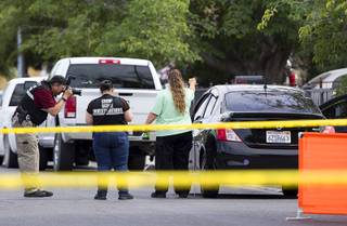 A North Las Vegas Police crime scene investigator takes a photo after a fatal shooting in a residential neighborhood near Cheyenne Avenue and Civic Center Drive in North Las Vegas Tuesday, May 30, 2017.