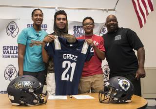 Nila Williams stands beside two prospective players Frank Bartley, 14, and Tavon Scott, 14, with Spring Valley High football head coach Marcus Teal as the program hosts a signing day event for incoming freshmen with hopes of drumming up interest to play on Tuesday, May 30, 2017.