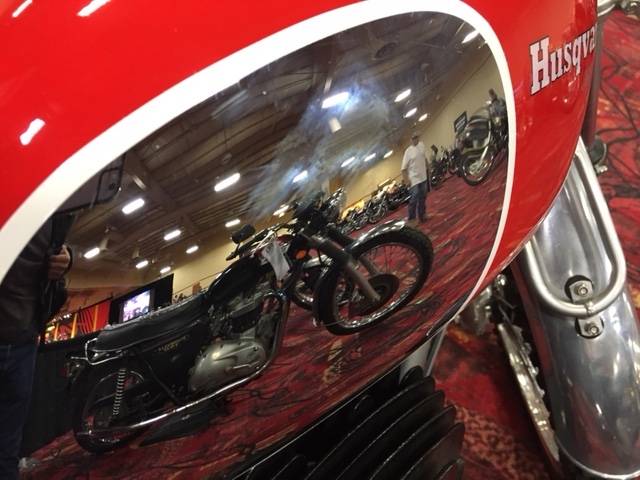A 1973 Triumph Bonneville is reflected in the chromed fuel tank of a 1969 Husqvarna dirt bike at the Mecum Las Vegas Motorcycle Auction. Bidding in the event, being held at the South Point Exhibit Hall, is scheduled to begin Friday, June 2, 2017.