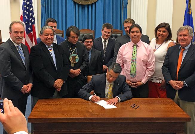 Gov. Brian Sandoval signs Senate Bill 375, which opens the door for negotiations about the use and sale of medical marijuana on tribal lands in Nevada, Friday, June 2, 2017.