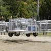 Tsubasa Nakamura, project leader of Cartivator, second from left, watches the flight of the test model of the flying car on a former school ground in Toyota, central Japan, Saturday, June 3, 2017. Cartivator Resource Management, in which Toyota invested 42.5 million yen ($386,000), showed to reporters a test flight of a concoction of aluminum framing and propellers. It took off several times, hovering at eye level for a few seconds, before falling to the ground. 