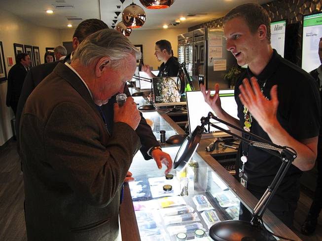 Nevada state Sen. Don Gustavson, R-Sparks, smells a sample of marijuana, Friday, March 24, 2017, as Christopher Price, a ''budtender'' at the Blum medical marijuana dispensary, describes the operation during a brief tour a the store on Virginia Street, about a mile south of the main casino district, in Reno.