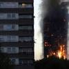 Smoke and flames rise from a building on fire in London, Wednesday, June 14, 2017. Metropolitan Police in London say they're continuing to evacuate people from a massive apartment fire in west London. The fire has been burning for more than three hours and stretches from the second to the 27th floor of the building.