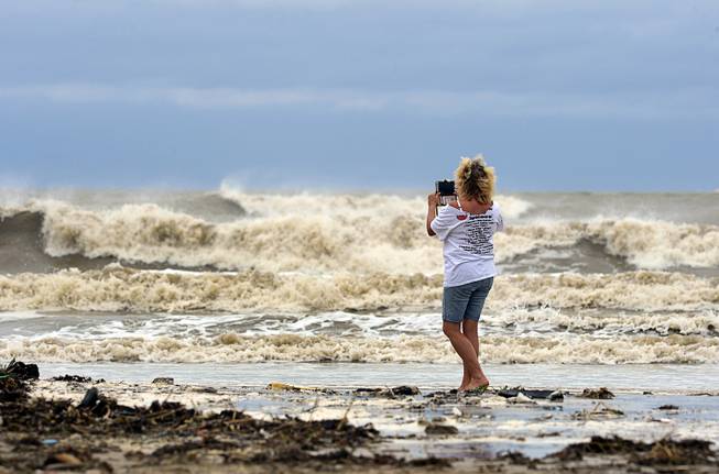 Tricia Hayes records images of unusually large waves created by Tropical Storm Cindy on Bolivar Peninsula, Texas, Wednesday, June 21, 2017. Texas Gov. Greg Abbott has ordered the State Operations Center to raise its readiness level. He also activated four Texas Task Force 1 boat squads and two Texas Military Department vehicles squads of five vehicles each to respond to any weather-related emergencies. 