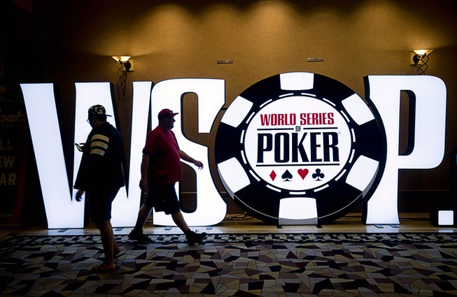 People pass by a WSOP sign in a hallway during ...