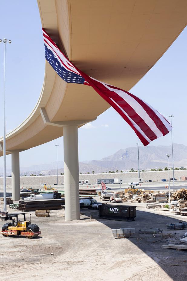 An 85-lb flag hangs from the newly completed 60 foot tall U.S. 95 / 215 Beltway or Centennial Bowl," flyover bridge during a ribbon cutting celebration, Wednesday, July 12, 2017. The flyover bridge, which cost $47 million and took almost two years to complete, connects the westbound 215 Beltway and southbound U.S. Highway 95.  Photo by Yasmina Chavez