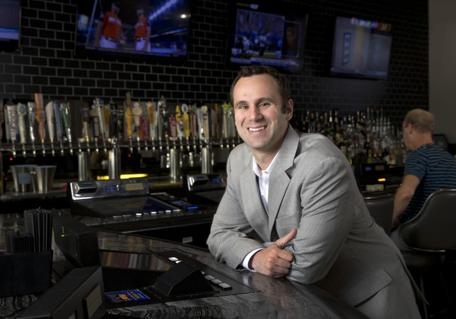 Sam Tibolt, owner of Proof Tavern, poses at the bar ...