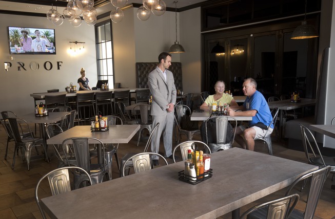 Sam Tibolt, owner of Proof Tavern, talks with his parents, ...