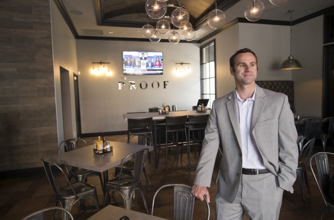 Sam Tibolt, owner of Proof Tavern, looks out from a ...