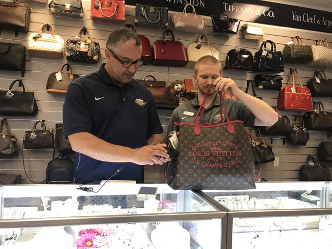 Michael Mack, left, and James McCracken of Max Pawn test the authenticity of a Louis Vuitton bag with the Entrupy microcamera device.