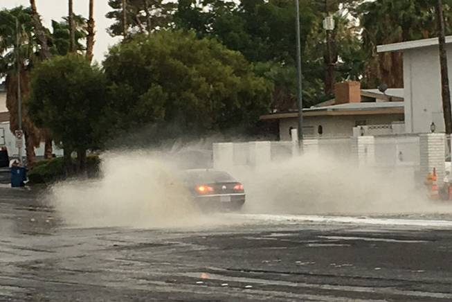 A car splashes through standing water on Eastern Avenue at Mohigan Way on Wednesday, July 19, 2017, during a thunderstorm in the Las Vegas Valley.

