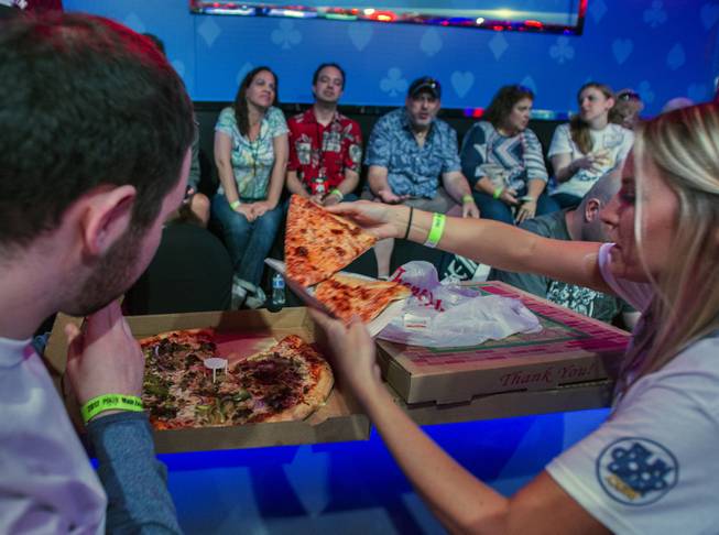 Fans enjoy a pizza break during the second of three straight nights to finish poker's world championship as the table goes from 7 to 3 players at the Rio on Friday, July 21 2017.