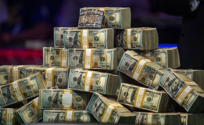 The winnings and jeweled bracelet are stacked on the table as Scott Blumstein looks to Dan Ott play for the win during the last night of the WSOP to finish poker's world championship at the Rio on Saturday, July 22 2017.