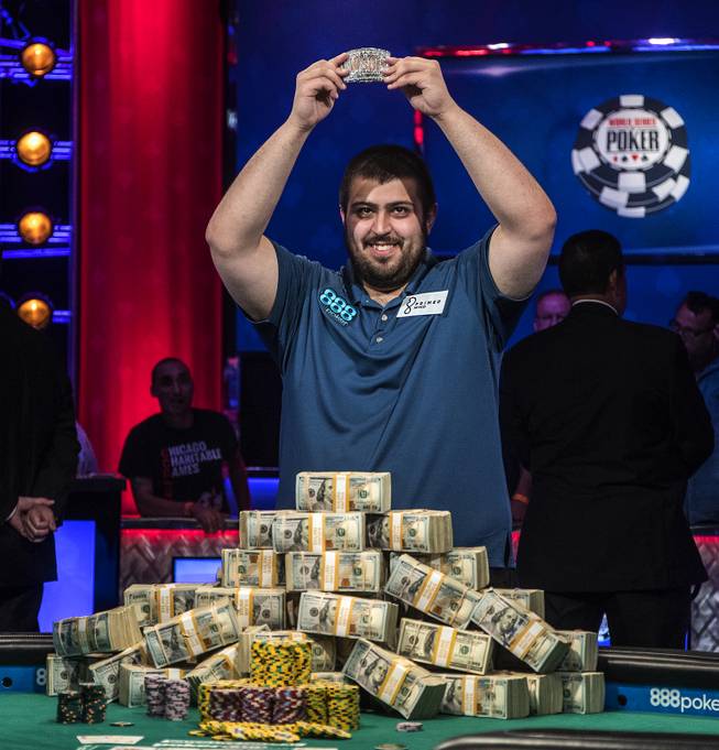 WSOP player Scott Blumstein shows off his bracelet before a pile of cash after winning poker's world championship at the Rio on Sunday, July 23 2017.