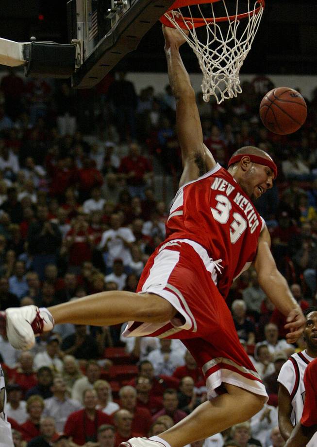 New Mexico's Patrick Dennehy hangs from the rim after a dunk against UNLV on Thursday, March 7, 2002, during the Mountain West Conference men's basketball tournament at the Thomas & Mack Center in Las Vegas. 