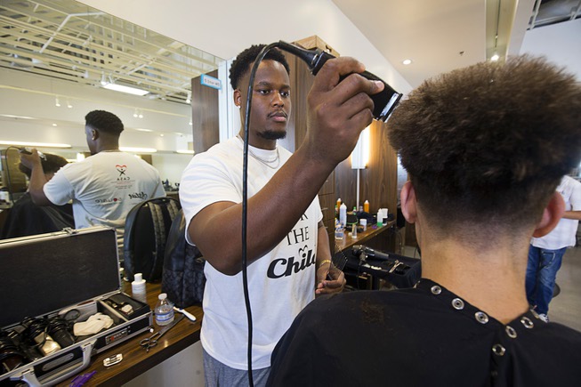 Stylist Will Lacy gives a haircut during a Back to ...