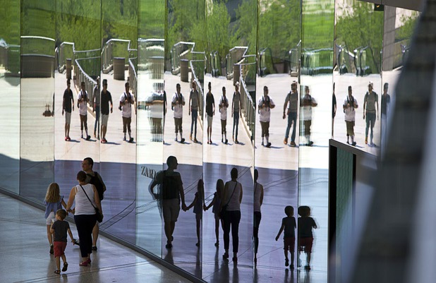Shoppers are reflected in a mirrored store front at the Fashion Show Mall on the Las Vegas Strip Tuesday, Aug. 8, 2017.