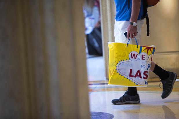 A man carries a shopping bag as he walks from the Canal Shoppes at the Venetian on the Las Vegas Strip Tuesday, Aug. 8, 2017.