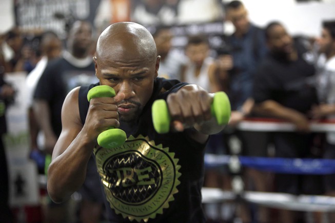 Floyd Mayweather Jr. shadow boxes with weights at the Mayweather ...