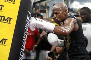 Floyd Mayweather Jr. hits a heavy bag during a workout at the Mayweather Boxing Club Thursday, Aug. 10, 2017.