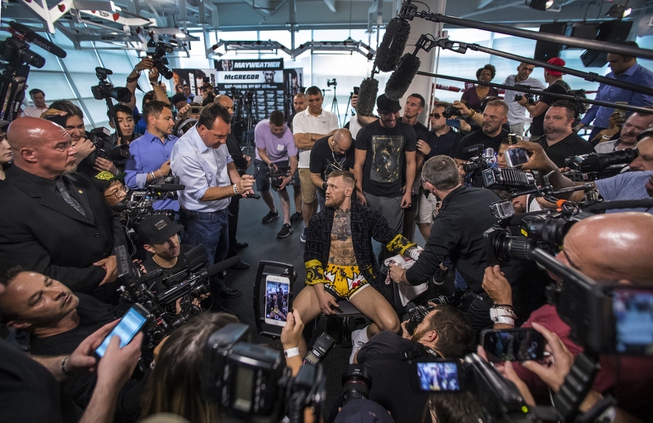 Conor McGregor chats with a reporter while being taped up ...