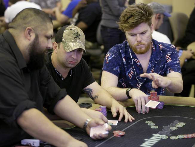 Dealer Richard Pope, left, works as Court Manuel, center, and Ed Wanson, right, play at Mint Poker, Thursday, Aug. 3, 2017, in Houston. The games at Mint Poker, which opened three months ago, are played in a large, quarter-circle-shaped room lined with ceiling-to-floor windows that illuminate the club with natural light during the day. Several of the more than 20 poker tables almost always have full games going, even during the middle of the afternoon.