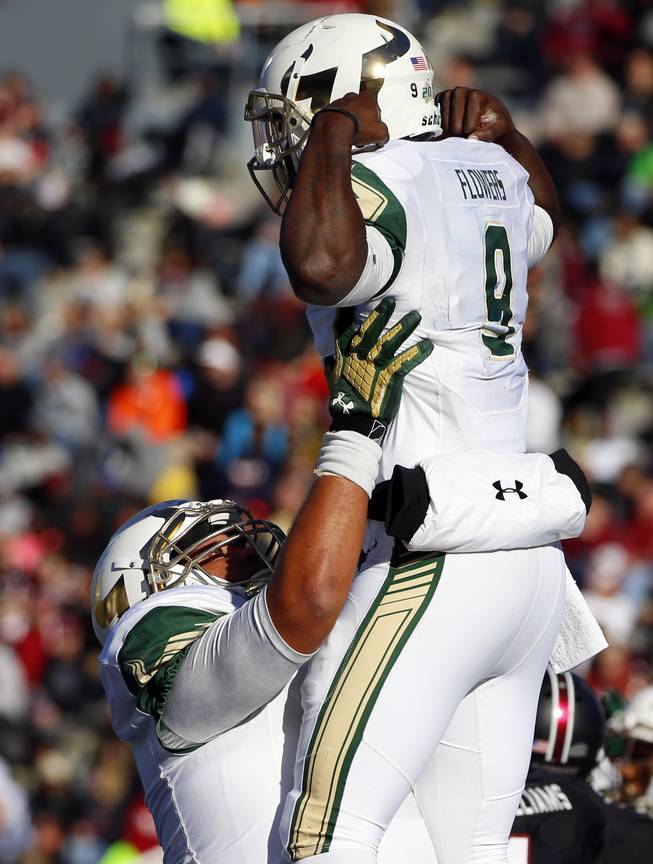 South Florida quarterback Quinton Flowers (9) is hoisted by a teammate celebrating his touchdown against South Carolina during the first half of the Birmingham Bowl NCAA college football game, Thursday, Dec. 29, 2016, in Birmingham, Ala.