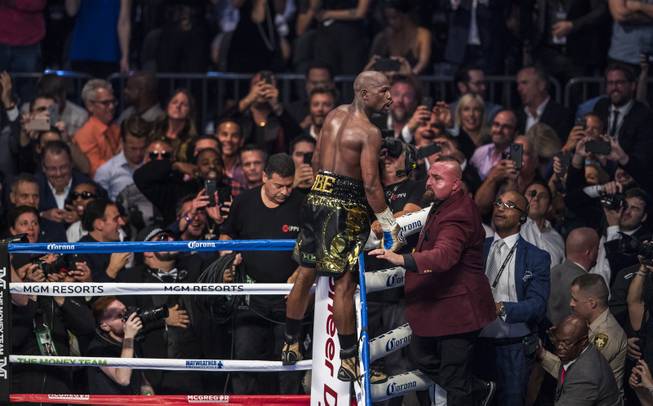 Super welterweight Floyd Mayweather Jr. celebrates is win over Conor McGregor standing on the ropes above the crowd at the T-Mobile Arena on Saturday, August 26, 2017.