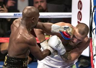 Super welterweight Floyd Mayweather Jr. drives a punch to the temple of Conor McGregor during their fight at the T-Mobile Arena on Saturday, August 26, 2017.