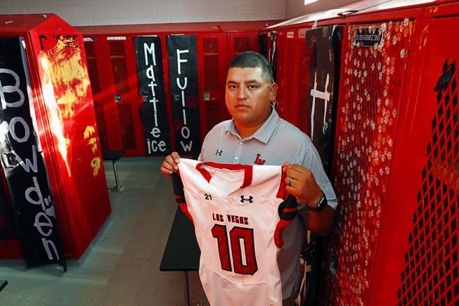 Las Vegas High School head coach Erick Capetillo poses by a locker kept vacant in memory of Eddie Gomez at the school Thursday, Sept. 7, 2017. Gomez, a player with the Las Vegas High School football team, died in 2003, two days after suffering a head injury in a playoff game. Capetillo was also a player on the team at the time.