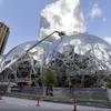In this April 27, 2017 file photo, construction continues on three large, glass-covered domes as part of an expansion of the Amazon.com campus in downtown Seattle. Amazon said Thursday, Sept. 7, 2017, that it will spend more than $5 billion to build another headquarters in North America to house as many as 50,000 employees. It plans to stay in its sprawling Seattle headquarters and the new space will be "a full equal" of its current home, said founder and CEO Jeff Bezos.