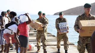 In this undated photo provided on Tuesday, Sept. 12, 2017 by the British Ministry of Defence, Royal Marines deliver aid and provide support to the islanders of Jost Van Dkye, British Virgin Islands. The team helped to deliver essential aid utilising a small boat to support this isolated community of just 300 people. Britain sent a navy ship and almost 500 troops to the British Virgin Islands, Anguilla and the Turks and Caicos islands. (MOD via AP)