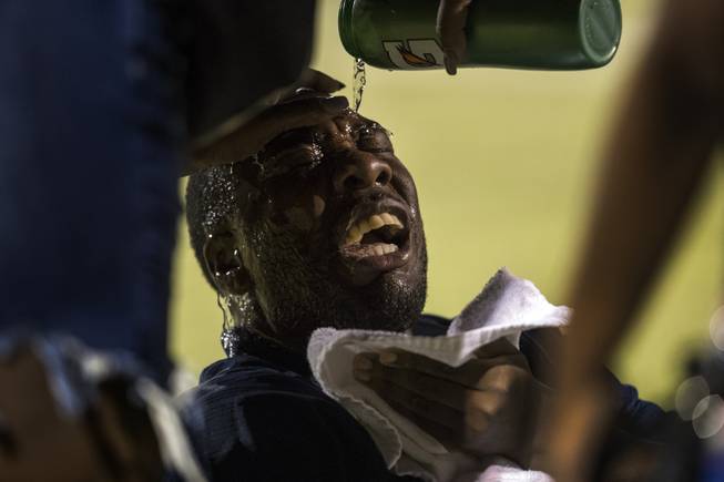 Canyon Springs head coach Gus McNair winces in pain from ...